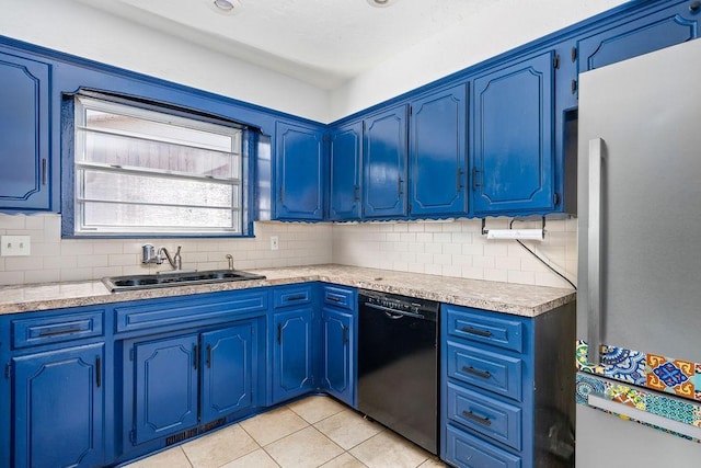 kitchen featuring freestanding refrigerator, black dishwasher, a sink, and tasteful backsplash