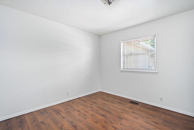 empty room featuring wood finished floors and baseboards