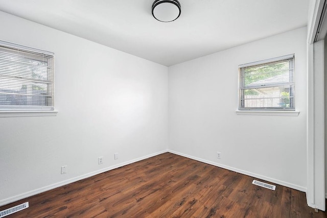 spare room with dark wood finished floors and baseboards
