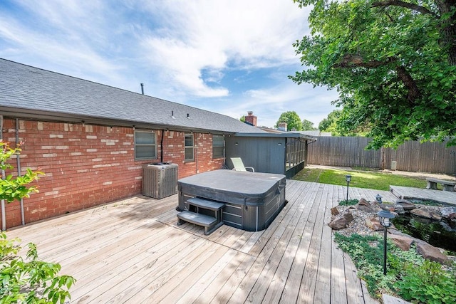 deck with a hot tub, central air condition unit, and a fenced backyard