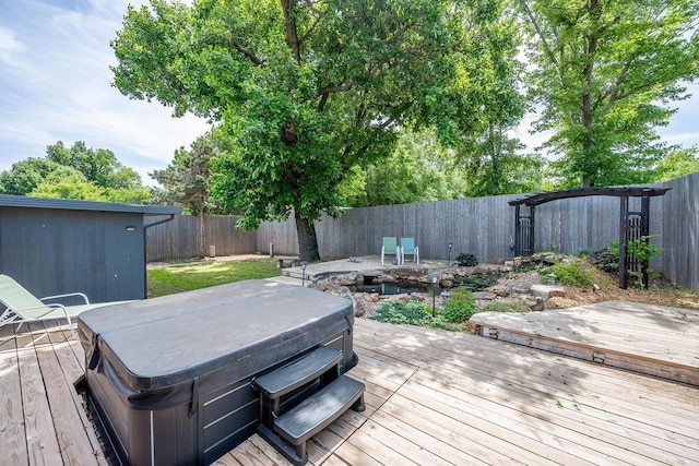 wooden terrace featuring a hot tub and a fenced backyard