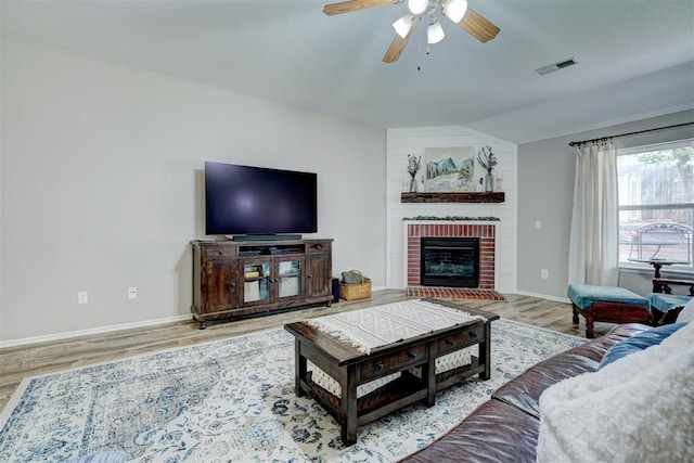 12308 Hickory Creek Blvd, Oklahoma City, OK 73170 - living room featuring a ceiling fan, wood finished floors, vaulted ceiling, baseboards, and a brick fireplace
