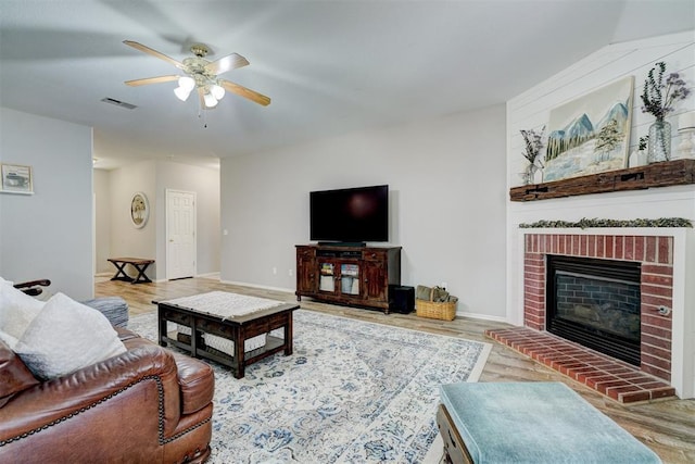 12308 Hickory Creek Blvd, Oklahoma City, OK 73170 - living room featuring ceiling fan, wood finished floors, baseboards, and a brick fireplace