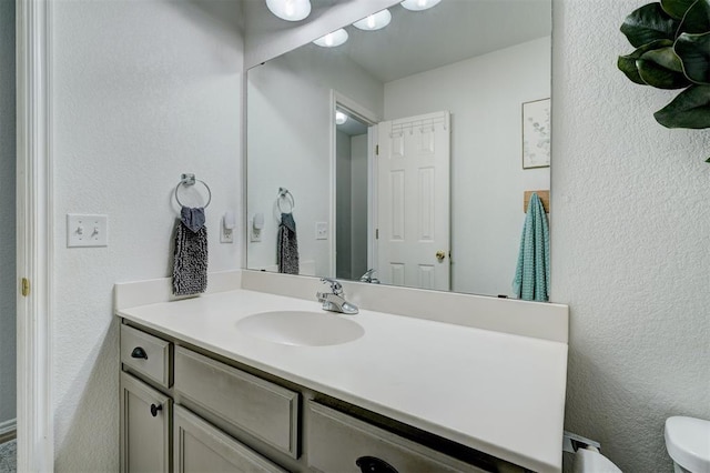 12308 Hickory Creek Blvd, Oklahoma City, OK 73170 - half bath with vanity, a textured wall, and toilet