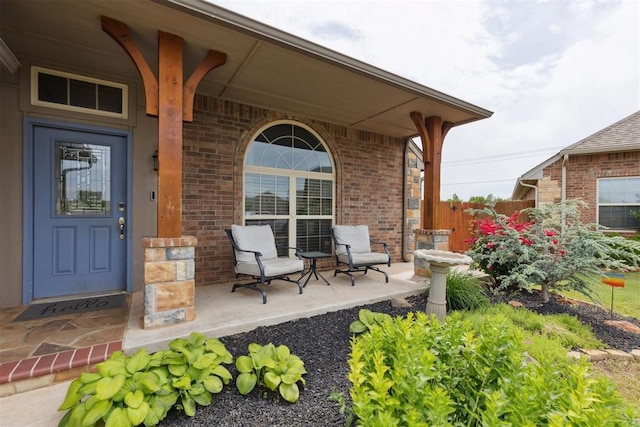 12116 NW 137th St, Piedmont, OK 73078 - view of exterior entry with a porch, brick siding, and fence