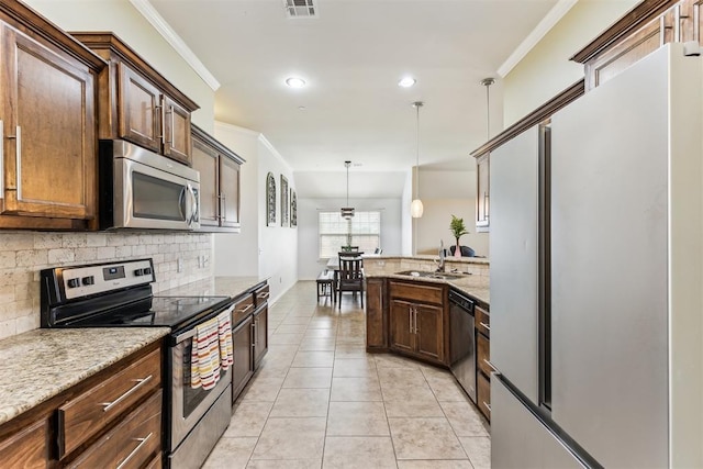 12116 NW 137th St, Piedmont, OK 73078 - kitchen featuring appliances with stainless steel finishes, a sink, ornamental molding, decorative backsplash, and a peninsula