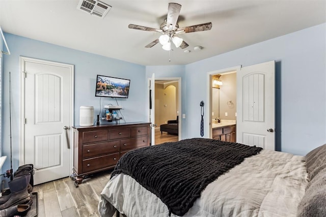 12116 NW 137th St, Piedmont, OK 73078 - bedroom featuring light wood finished floors, connected bathroom, a sink, and a ceiling fan