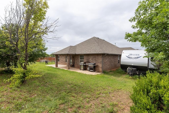 12116 NW 137th St, Piedmont, OK 73078 - rear view of house with brick siding, a patio, a lawn, and a shingled roof