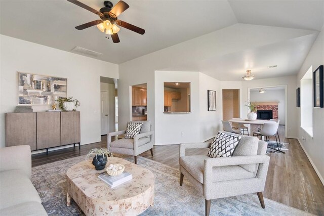 2013 Cedar Meadow Ln, Edmond, OK 73003 - living area with wood finished floors, ceiling fan, vaulted ceiling, a brick fireplace, and baseboards