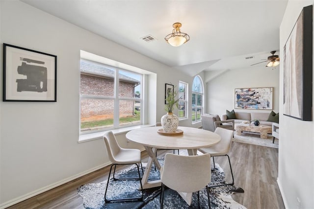 2013 Cedar Meadow Ln, Edmond, OK 73003 - dining space featuring wood finished floors, baseboards, ceiling fan, and vaulted ceiling