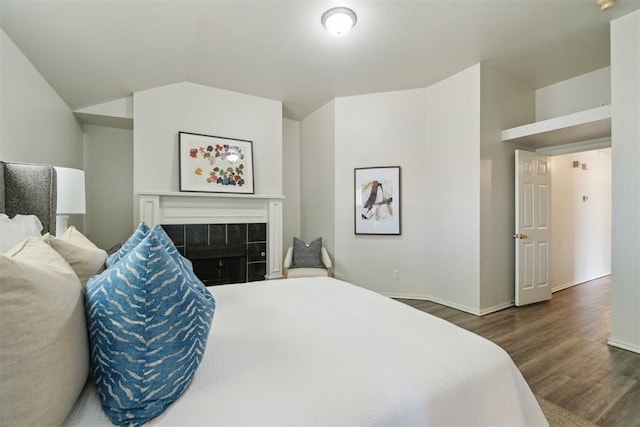 2013 Cedar Meadow Ln, Edmond, OK 73003 - bedroom with wood finished floors, a fireplace, baseboards, and vaulted ceiling