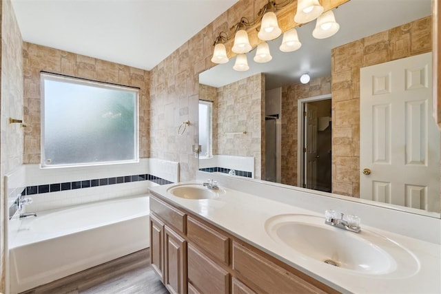 2013 Cedar Meadow Ln, Edmond, OK 73003 - bathroom featuring tile walls, a garden tub, double vanity, a shower, and wood finished floors
