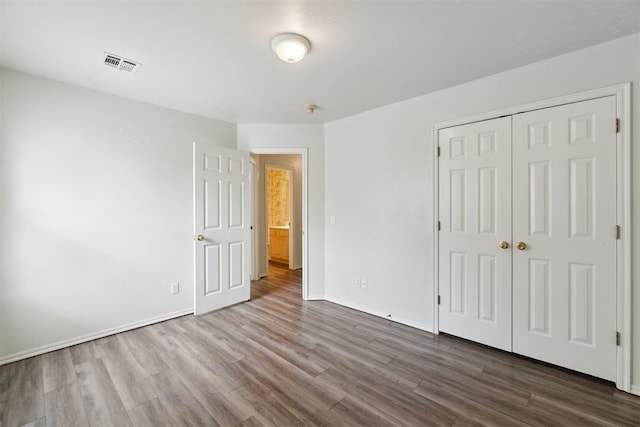 2013 Cedar Meadow Ln, Edmond, OK 73003 - unfurnished bedroom featuring dark wood finished floors, a closet, and baseboards