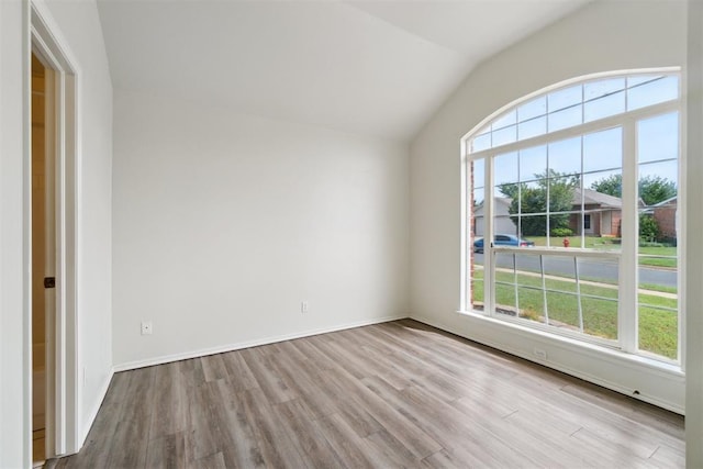 2013 Cedar Meadow Ln, Edmond, OK 73003 - empty room featuring plenty of natural light, wood finished floors, lofted ceiling, and baseboards