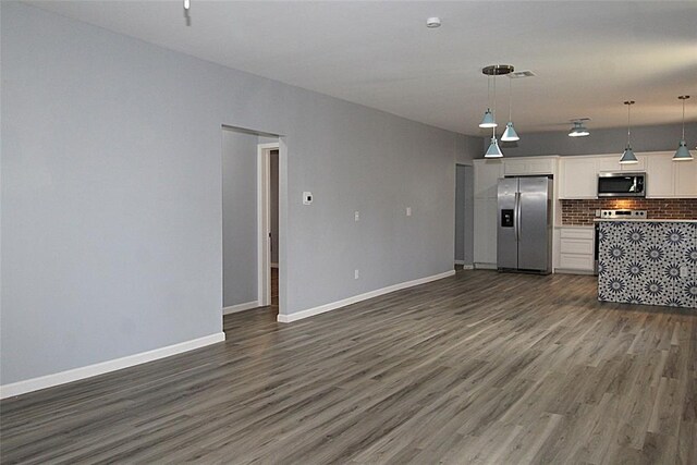 1016 N Louisa Ave, Shawnee, OK 74801 - unfurnished living room featuring dark wood finished floors and baseboards