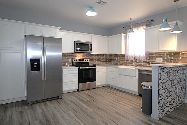 1016 N Louisa Ave, Shawnee, OK 74801 - kitchen with appliances with stainless steel finishes, a sink, light countertops, light wood-type flooring, and tasteful backsplash