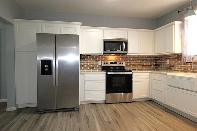 1016 N Louisa Ave, Shawnee, OK 74801 - kitchen with stainless steel appliances, a sink, light countertops, light wood-style floors, and white cabinetry