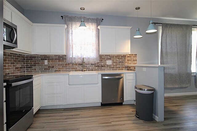 1016 N Louisa Ave, Shawnee, OK 74801 - kitchen with stainless steel appliances, a sink, wood finished floors, and white cabinetry