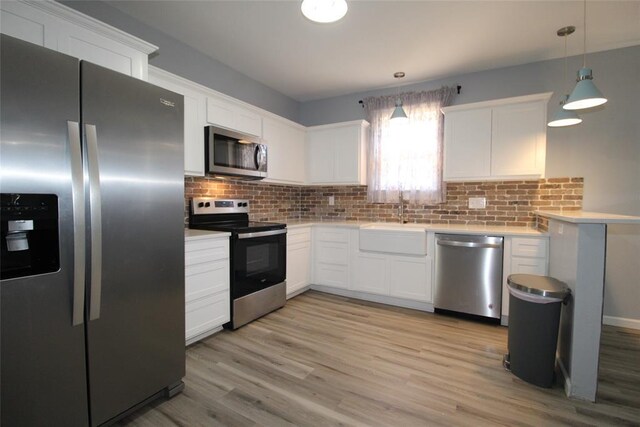 1016 N Louisa Ave, Shawnee, OK 74801 - kitchen with stainless steel appliances, a sink, light countertops, decorative backsplash, and white cabinetry