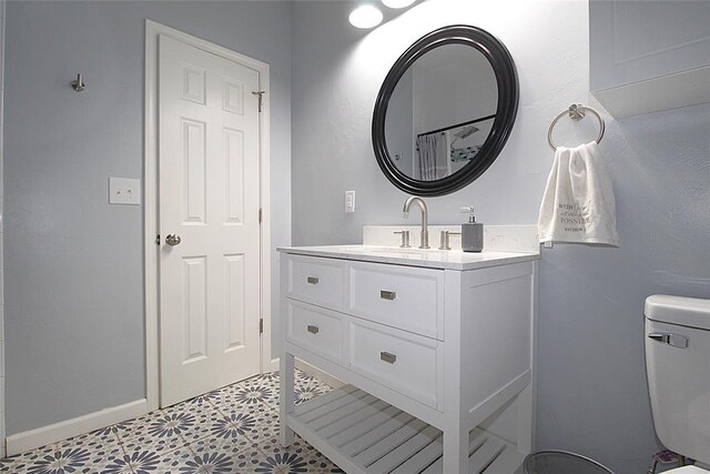 1016 N Louisa Ave, Shawnee, OK 74801 - bathroom with vanity, toilet, baseboards, and tile patterned floors