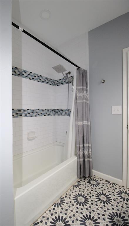 1016 N Louisa Ave, Shawnee, OK 74801 - bathroom with shower / tub combo with curtain, baseboards, and tile patterned flooring