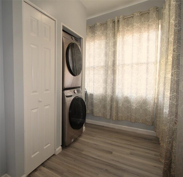 1016 N Louisa Ave, Shawnee, OK 74801 - laundry room featuring stacked washer / drying machine, wood finished floors, and baseboards