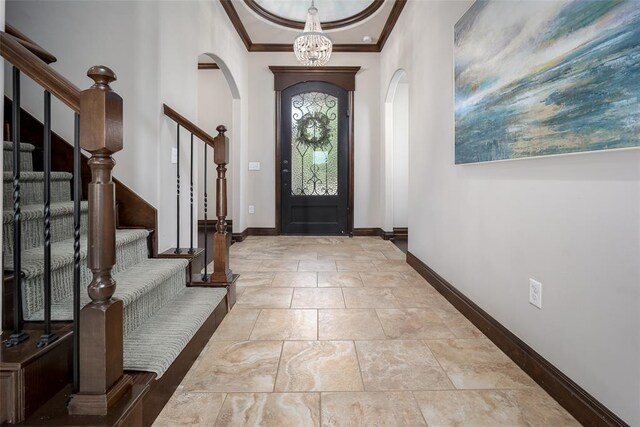 3716 Doningham Dr, Edmond, OK 73034 - foyer with arched walkways, crown molding, baseboards, stairway, and a chandelier