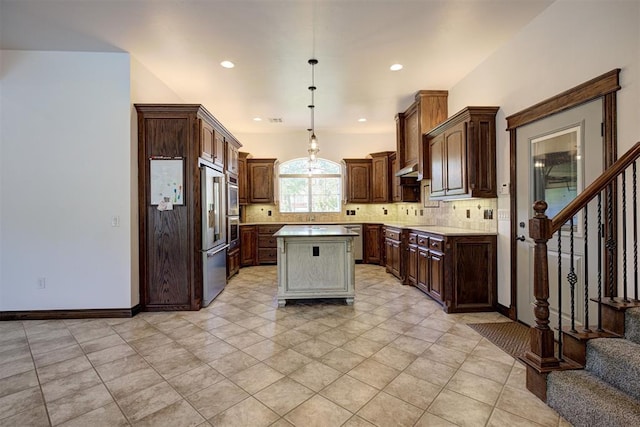 16371 Sandstone Cir, Choctaw, OK 73020 - kitchen with a kitchen island, appliances with stainless steel finishes, backsplash, light countertops, and hanging light fixtures