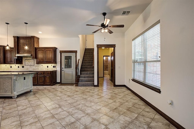 16371 Sandstone Cir, Choctaw, OK 73020 - kitchen with decorative backsplash, ceiling fan, dark brown cabinetry, pendant lighting, and baseboards