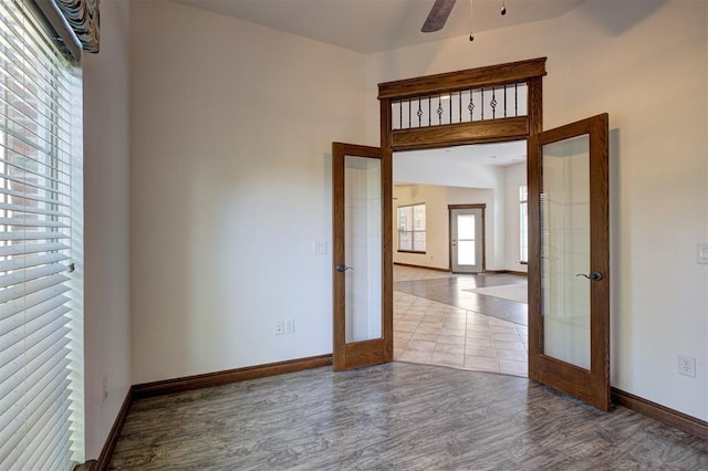 16371 Sandstone Cir, Choctaw, OK 73020 - unfurnished room with french doors, baseboards, wood finished floors, a ceiling fan, and a towering ceiling