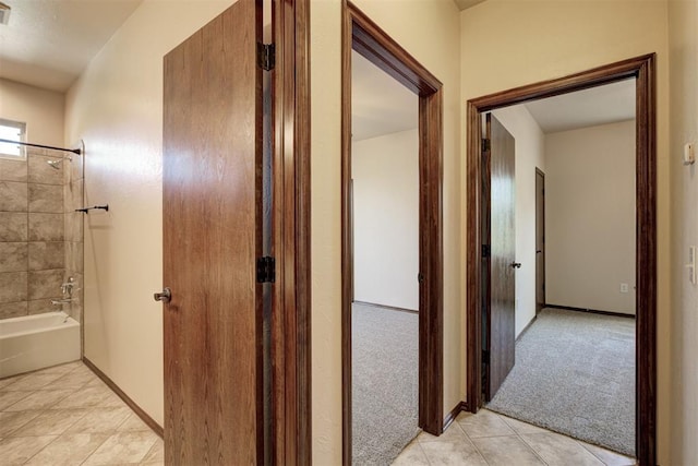 16371 Sandstone Cir, Choctaw, OK 73020 - corridor featuring light tile patterned floors, light colored carpet, and baseboards