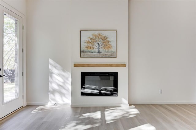 577 S Fretz Ave, Edmond, OK 73003 - living area featuring wood finished floors, a fireplace with flush hearth, and baseboards