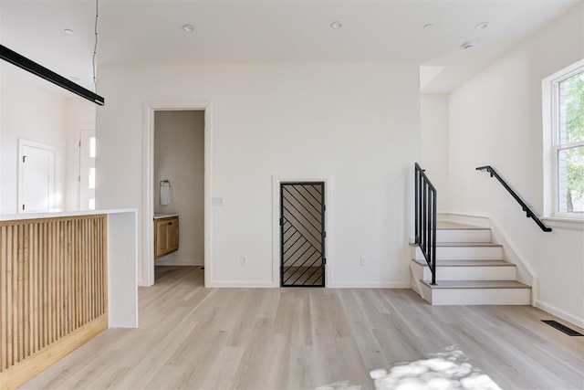 577 S Fretz Ave, Edmond, OK 73003 - unfurnished living room with light wood-style floors, stairway, and baseboards