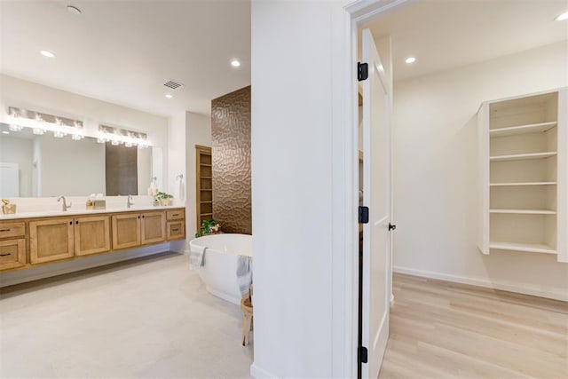 577 S Fretz Ave, Edmond, OK 73003 - full bath featuring double vanity, a freestanding bath, recessed lighting, baseboards, and wood finished floors