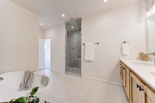 577 S Fretz Ave, Edmond, OK 73003 - full bath featuring a shower stall, a freestanding tub, double vanity, recessed lighting, and baseboards