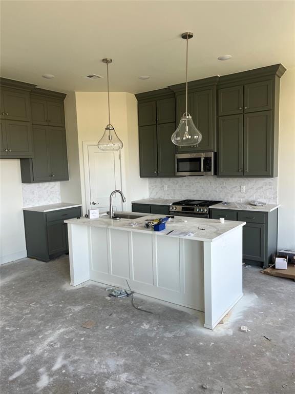 kitchen with appliances with stainless steel finishes, decorative backsplash, a center island with sink, and hanging light fixtures
