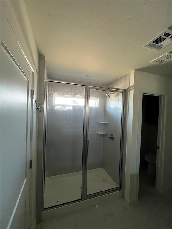 full bathroom with a shower stall and toilet
