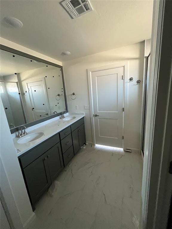 bathroom with double vanity and marble finish floors