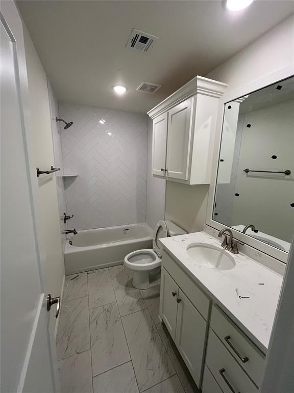 bathroom with marble finish flooring, toilet, washtub / shower combination, vanity, and recessed lighting