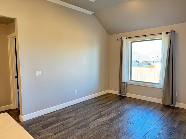 unfurnished room with dark wood-style flooring, lofted ceiling, and baseboards