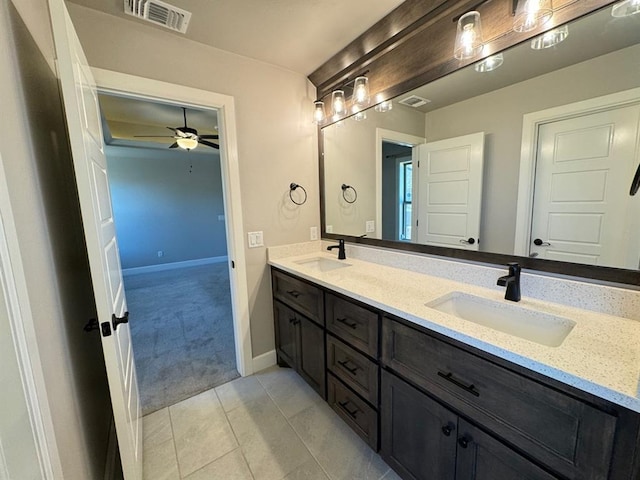 full bathroom featuring ceiling fan, double vanity, tile patterned floors, and baseboards