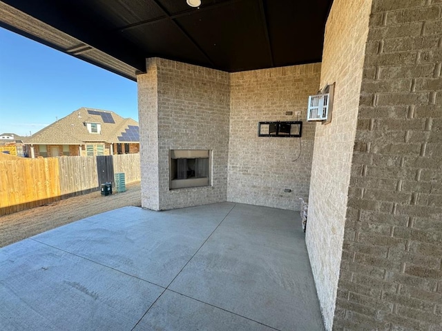 view of patio / terrace with an outdoor brick fireplace and fence