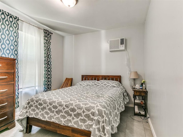 bedroom featuring a wall mounted AC and baseboards