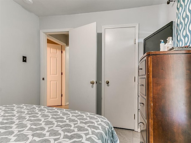 bedroom with a closet and light tile patterned flooring
