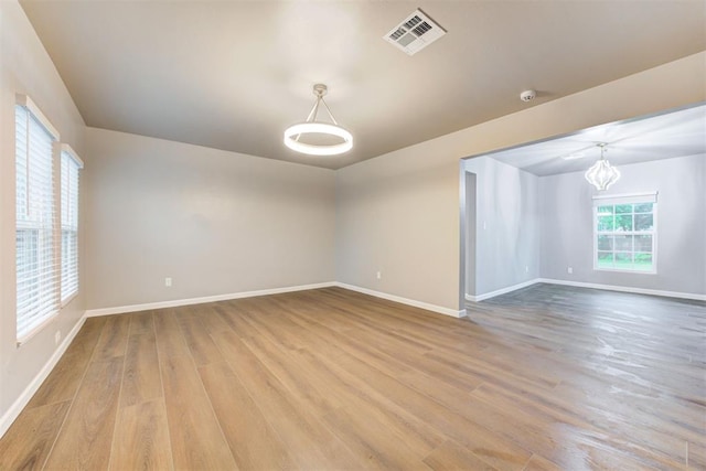 3128 NW 44th St, Oklahoma City, OK 73112 - empty room with wood finished floors, baseboards, a chandelier, and a smoke detector