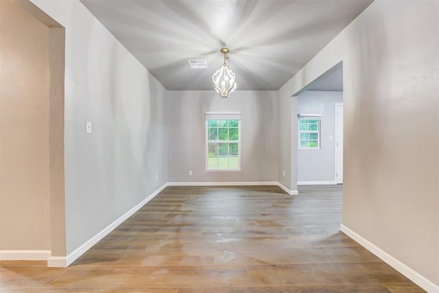 3128 NW 44th St, Oklahoma City, OK 73112 - unfurnished room featuring baseboards, wood finished floors, and a chandelier
