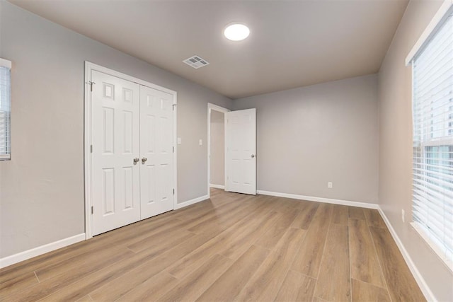 3128 NW 44th St, Oklahoma City, OK 73112 - unfurnished bedroom featuring light wood-style floors, multiple windows, baseboards, and a closet