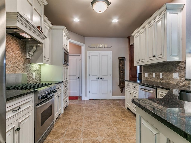 404 Nantucket Blvd, Norman, OK 73071 - kitchen with stainless steel appliances, decorative backsplash, dark stone counters, premium range hood, and white cabinets