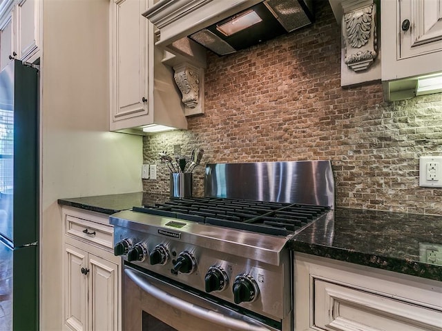 404 Nantucket Blvd, Norman, OK 73071 - kitchen featuring gas range, freestanding refrigerator, backsplash, range hood, and dark stone countertops