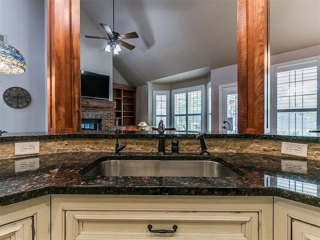 404 Nantucket Blvd, Norman, OK 73071 - kitchen featuring a sink, a ceiling fan, vaulted ceiling, plenty of natural light, and dark stone counters